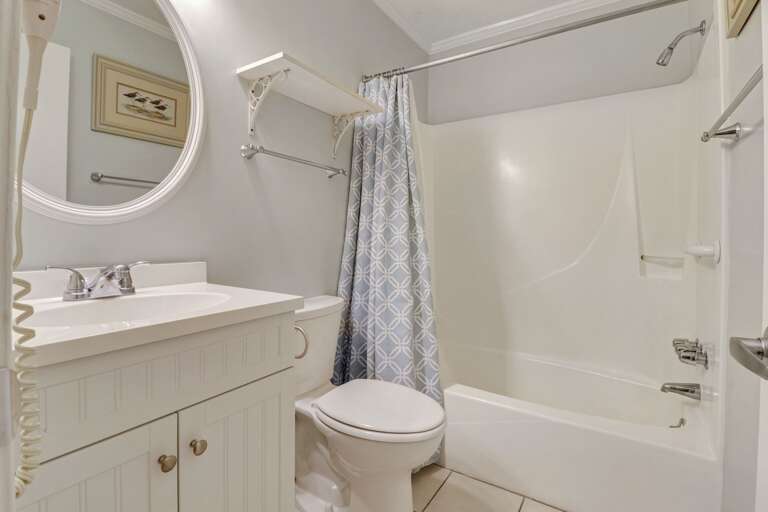 Bright, white bathroom with shower/tub combination 