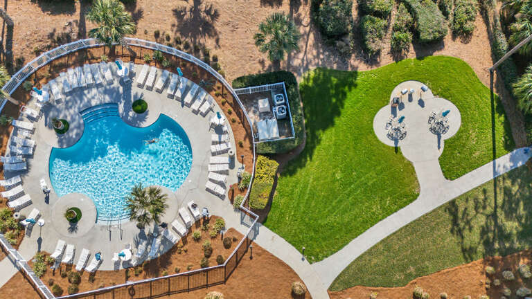 Aerial View Of A Swimming Pool Surrounded By Sun Loungers And Trees