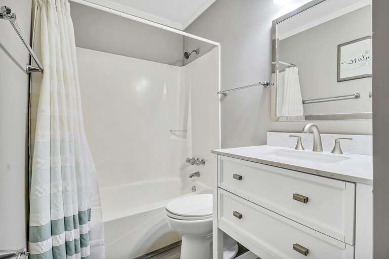 Bright and beachy bathroom with tub/shower combination 