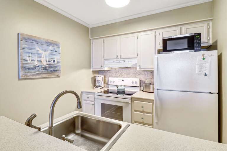 Kitchen fully equipped with fridge, oven, dishwasher, coffee maker, microwave, toaster, utensils and more.