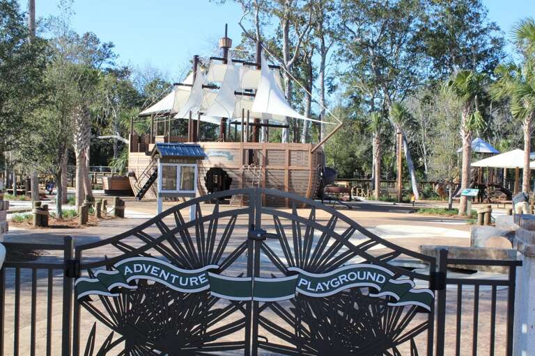 Playground With Pirate Ship Design Behind Themed Gate