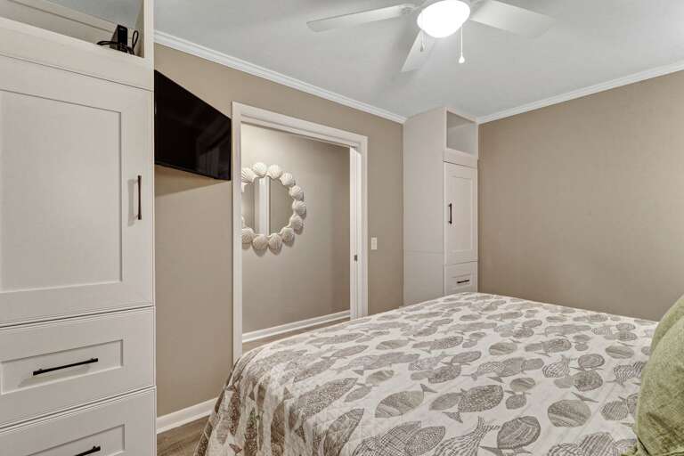 Plenty of storage, along with wall mounted, flat screen TV in king sized bedroom. 