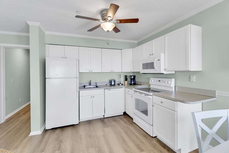 The beautiful, all white kitchen has new appliances and a ceiling fan to keep cool while preparing your favorite meal.