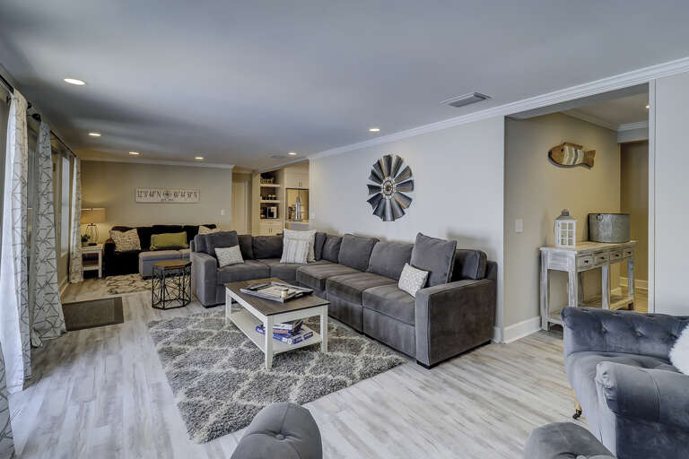 Spacious living room area with flat screen TV and sleep sofa bed by far wall.  Spacious living room area with flat screen TV and sleep sofa bed by far wall.