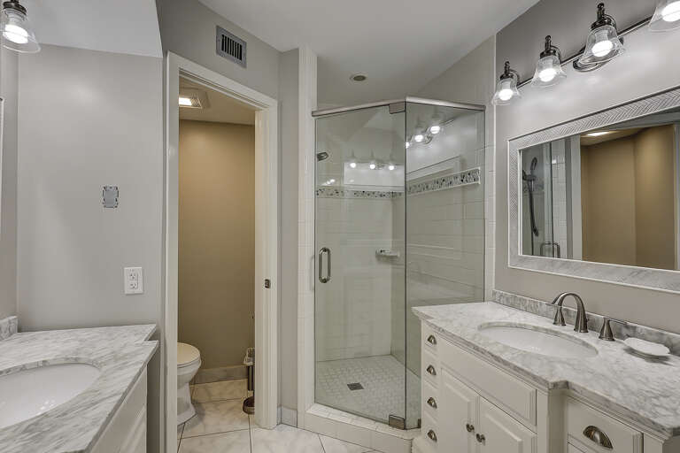 Seamlessly connected to the Master Suite, the newly renovated bathroom includes dual vanities and a modern walk-in shower with stylish finishes.