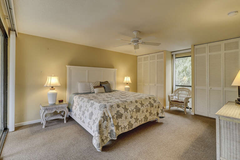 Spacious master bedroom with king sized bed,  ensuite bathroom and private balcony overlooking a lagoon.   