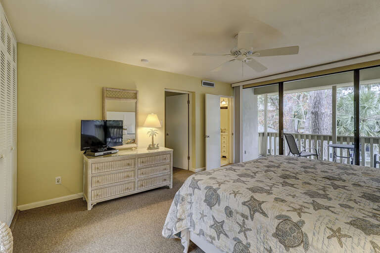 Spacious master bedroom with king sized bed,  ensuite bathroom and private balcony overlooking a lagoon.   