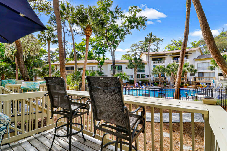 Deck offers grill a beautiful view overlooking the pool and palm trees. Table with umbrella seats four. Also four extra high chair seating.