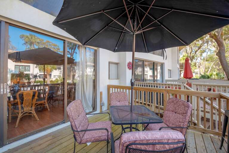 Deck offers grill nice view overlooking the pool. Table with umbrella seats four  .