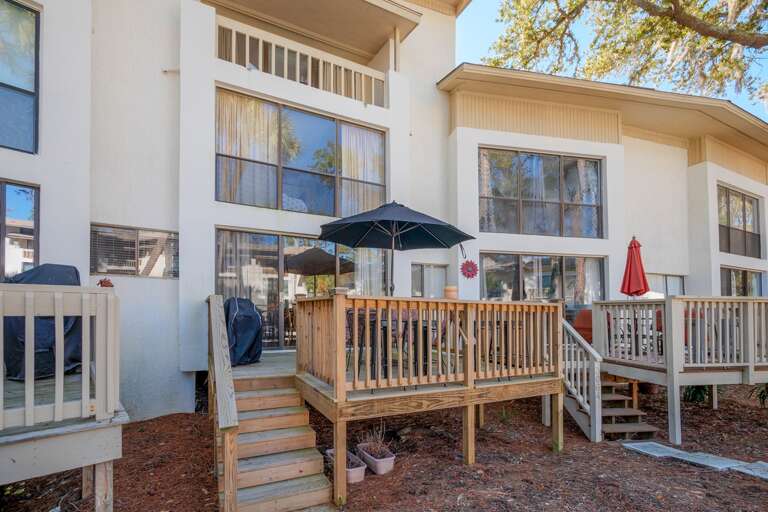 Deck offers grill a beautiful view overlooking the pool and palm trees. Table with umbrella seats four. Also four extra high chair seating.