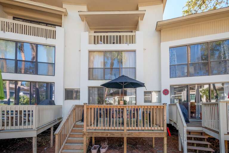 Deck offers grill a beautiful view overlooking the pool and palm trees. Table with umbrella seats four. Also four extra high chair seating.