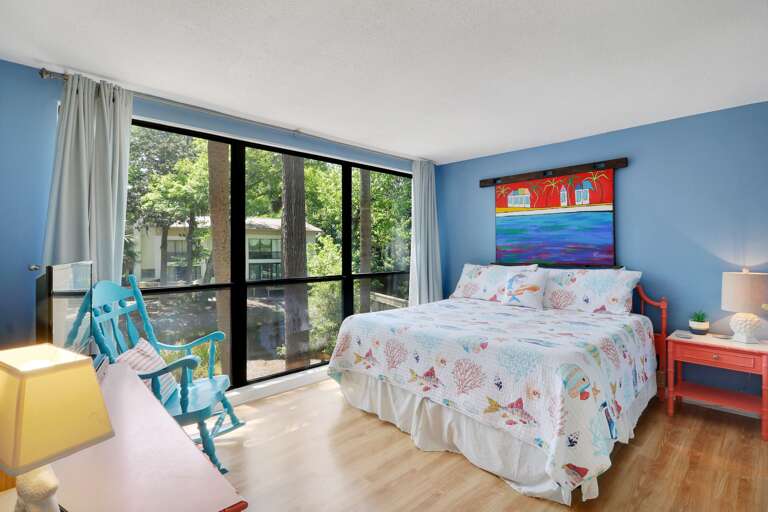 Bright coastal colors in this king sized bedroom with beautiful view overlooking the grounds.  