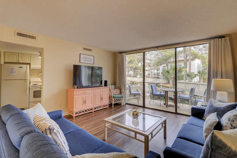 The living room area has sliding door access to the lagoon view with a wooden deck. Upscale furnishings and a flat screen television complete the space.