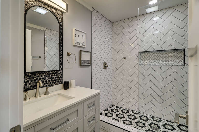 The bathroom in this Sea Side Villa 122 has a glass and tile shower.  The tile work in the shower offers an interesting design and a built-in niche for toiletries. 