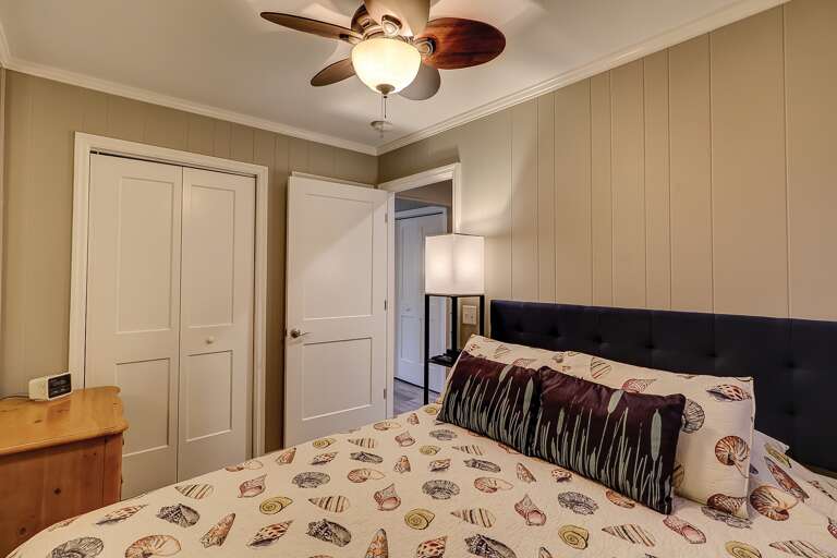 Interior Bedroom With Bed, Ceiling Fan, And Doors