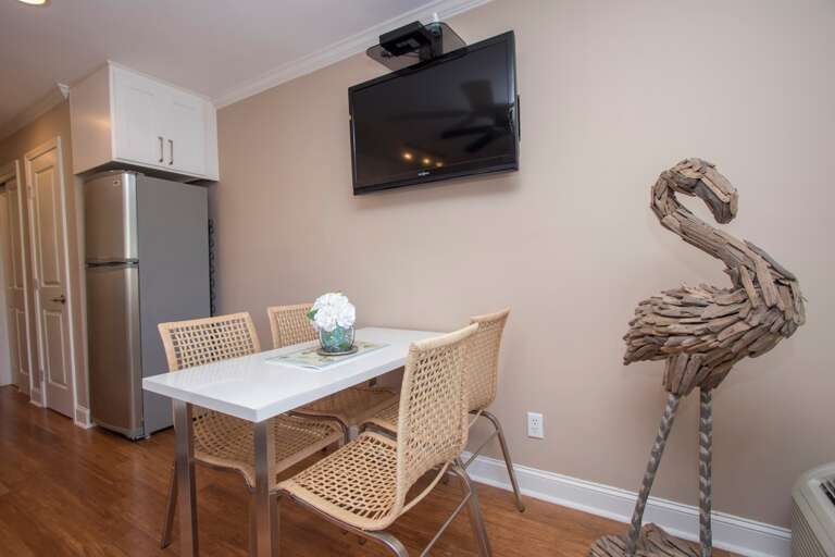 The large, wall-mounted flat-screen TV is centrally placed so it can watched from the dining table or the sofa.