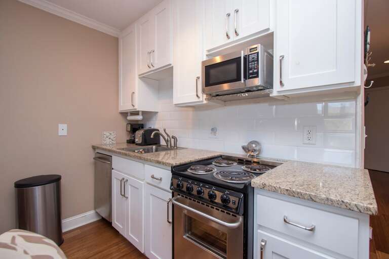 The newly refurbished kitchen has stainless steel appliances and granite counter tops.