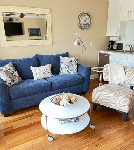 Living Room With Blue Sofa, Armchair, And Round Coffee Table