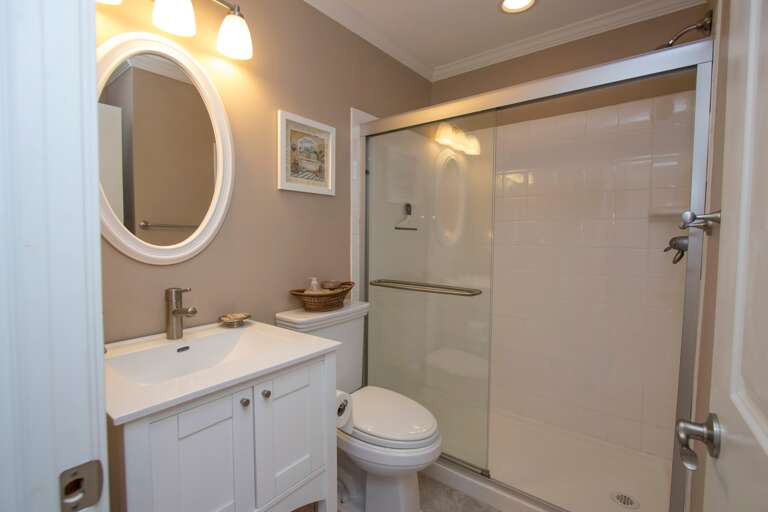 The beautifully updated bathroom has a tile and glass walk-in shower.