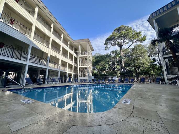 Blue Pool Between Buildings Under Bright Sky