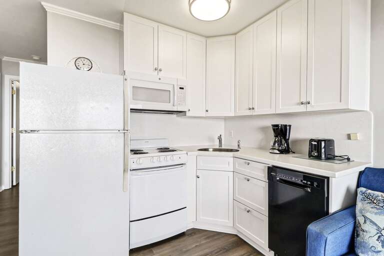 Bright white compact kitchen with all major appliances and regular drip coffeemaker.  