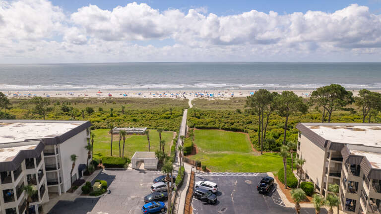 Aerial View Of Beachfront Residential Buildings With Parking Lot And Ocean View Aerial View Of Beachfront Residential Buildings With Parking Lot And Ocean View