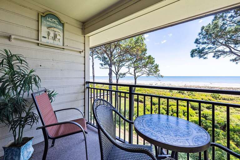 Balcony With Chairs And Table Overlooking Sea And Trees