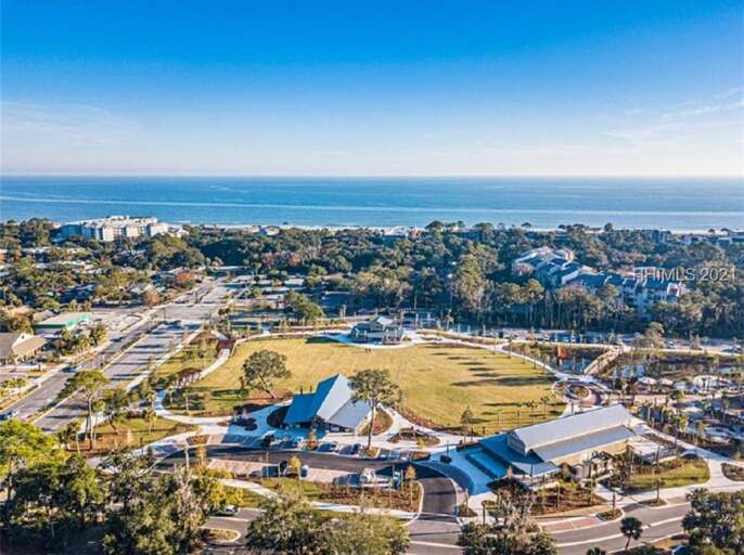 Aerial View Of A Seaside Village With Buildings And Trees, Blue Sky