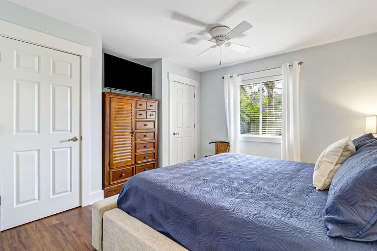 The master bedroom features a king bed with side tables and lamps for plenty of soft lighting.  Additionally it is furnished with a dresser for clothing storage as well as two closets