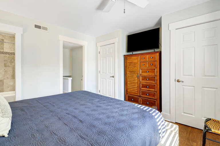 The master bedroom features a king bed with side tables and lamps for plenty of soft lighting.  Additionally it is furnished with a dresser for clothing storage as well as two closets
