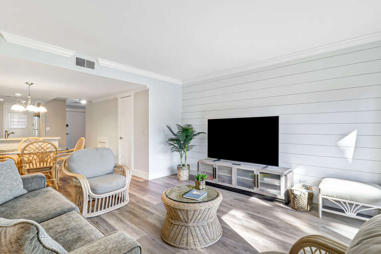  The living room has a comfy sofa bed, wall mounted smart flat screen T.V. and sliding door to balcony with amazing Beachfront view and Palm trees.