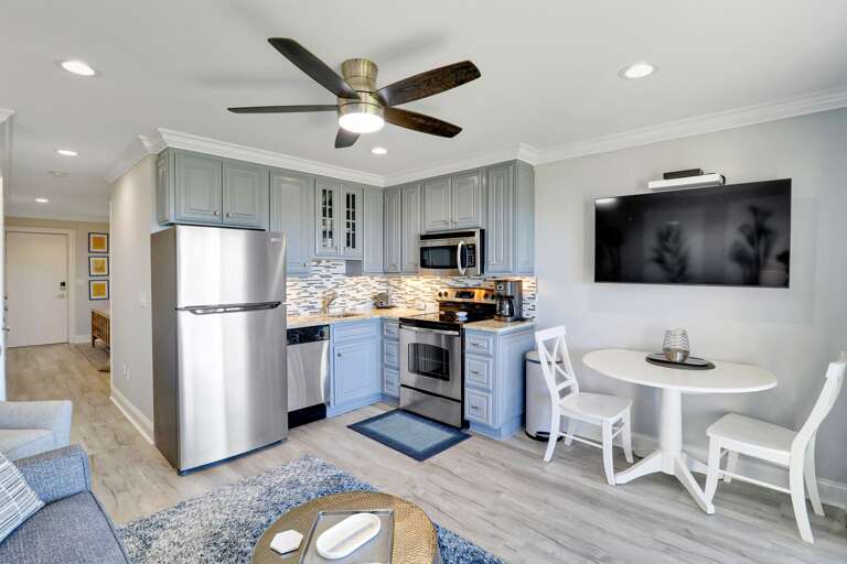 Bright Kitchen With Stainless Steel Appliances And Dining Area