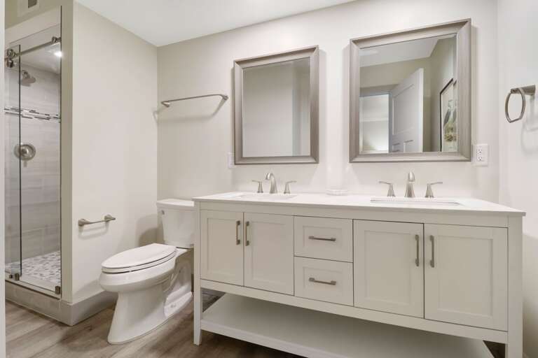 Completely renovated luxurious bathroom with walk-in tiled shower and double sinks. 