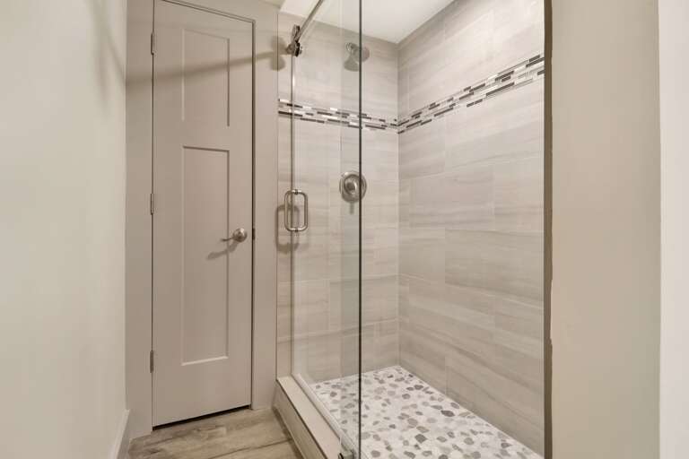 Large walk-in tiled shower with plenty of of storage space in closet. 