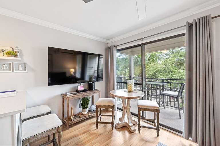 Living Room Interior With TV, Dining Table, And Balcony Access