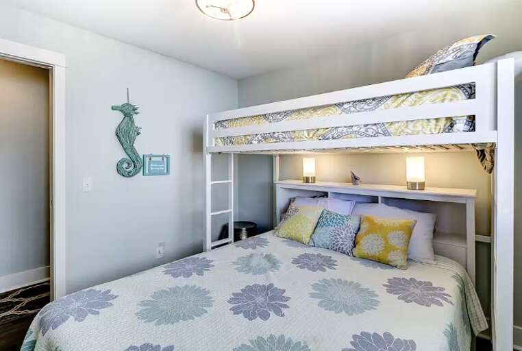 The guest bedroom includes a queen-size bed with an additional twin loft, perfect for small children. 