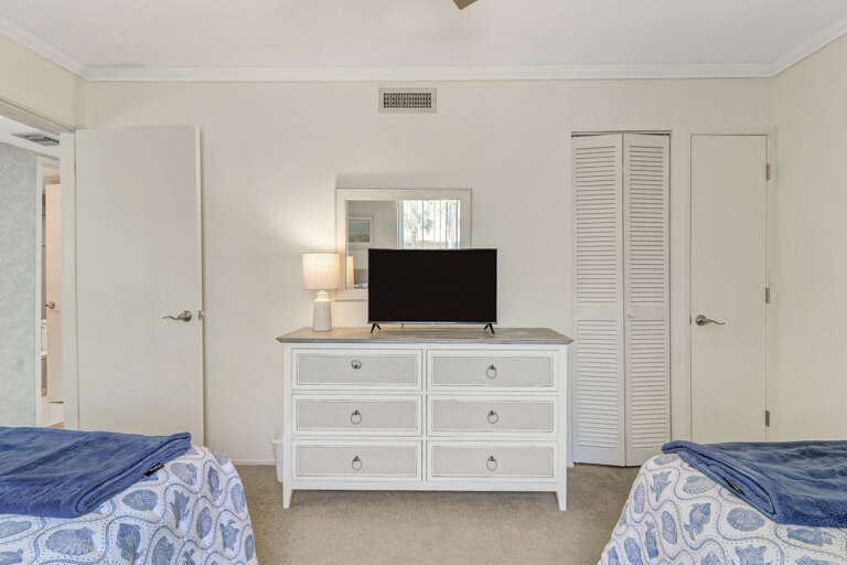 Guest Bed features two full size beds, a dresser and closet great for storage and a t.v. perfect for ending a cozy day at the beach.