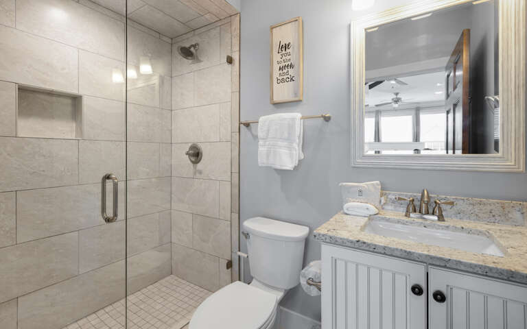 Your modern bathroom features a spacious walk-in shower and granite vanity, where fresh towels and thoughtful touches await your arrival.