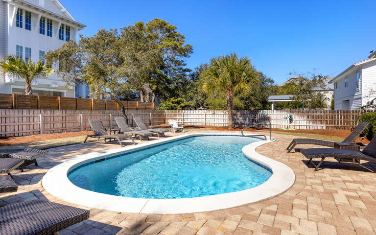Dive into your private oasis featuring crystal-clear waters surrounded by comfortable loungers on elegant stone decking.