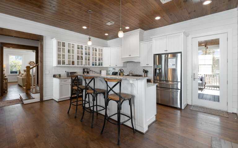 Your dream kitchen awaits with gleaming granite countertops, premium stainless appliances, and charming rustic wood ceiling beams overhead.