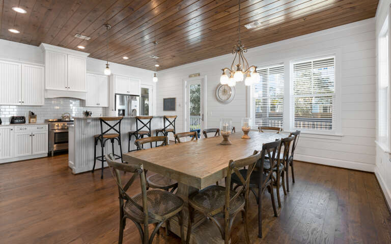 Gather around this stunning farmhouse dining table where your family meals become cherished memories beneath the warm wood ceiling.