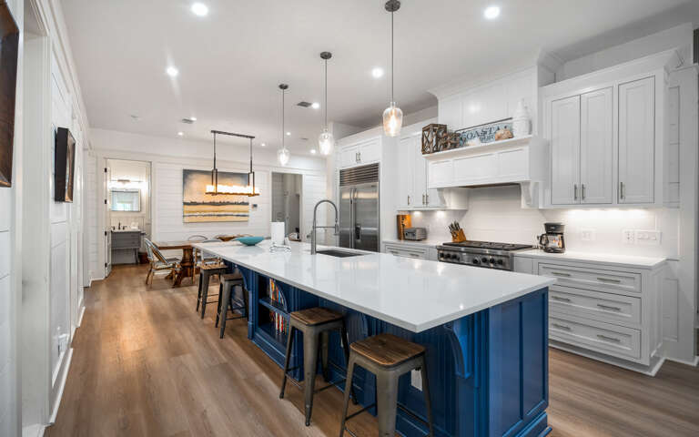 Your chef-worthy kitchen features a stunning blue island, gleaming quartz counters, and top-tier appliances ready for memorable meals together.