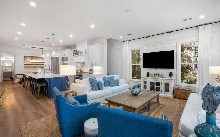 Relax in your open-concept living space where coastal blues meet crisp whites, creating the perfect backdrop for memorable vacation moments.