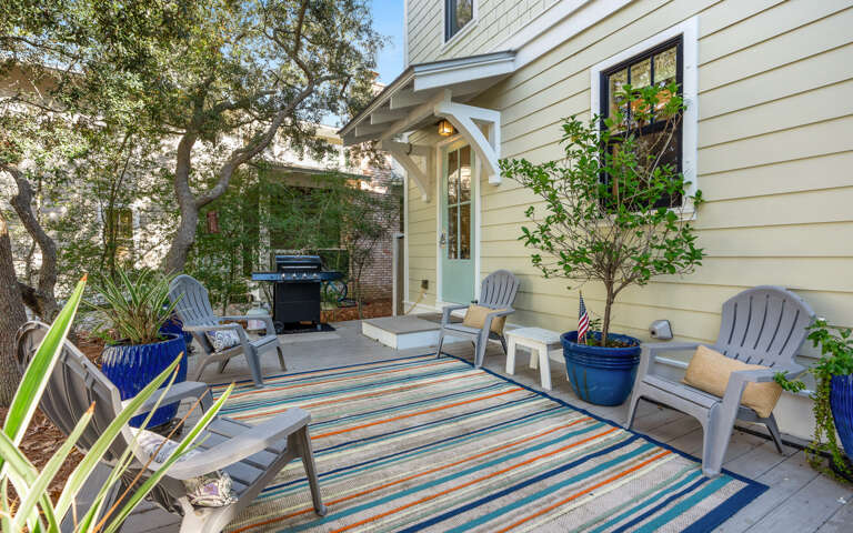 Your private patio beckons with cozy seating and a grill for memorable evenings under the trees.