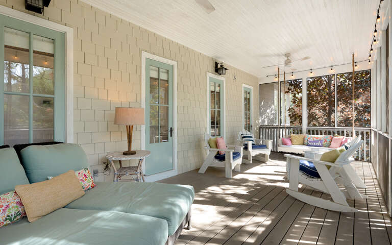 Unwind on your screened porch with coastal charm - colorful cushions, gentle breezes, and peaceful garden views create the perfect retreat.