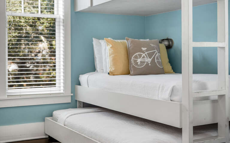 Relax in your serene space with cheerful accents and natural light filtering through stylish blinds.