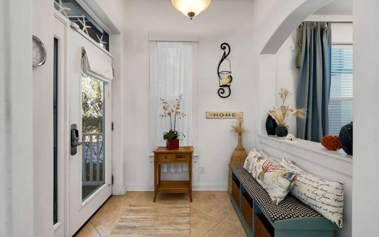 Your charming entryway welcomes you with warm lighting, cozy seating, and thoughtful touches that make arrival feel like coming home.