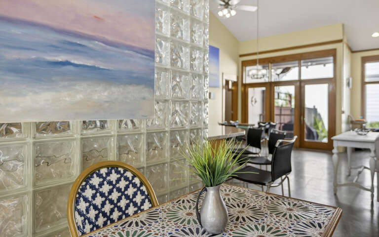 Glass-block Dining Space With Blue Chair, Vibrant Vessel, Vast View