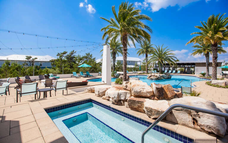 Outdoor Pool Area With Seating And Palm Trees