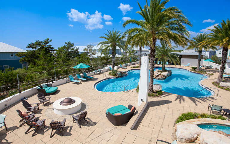 Outdoor Swimming Pool With Palm Trees And Lounge Chairs